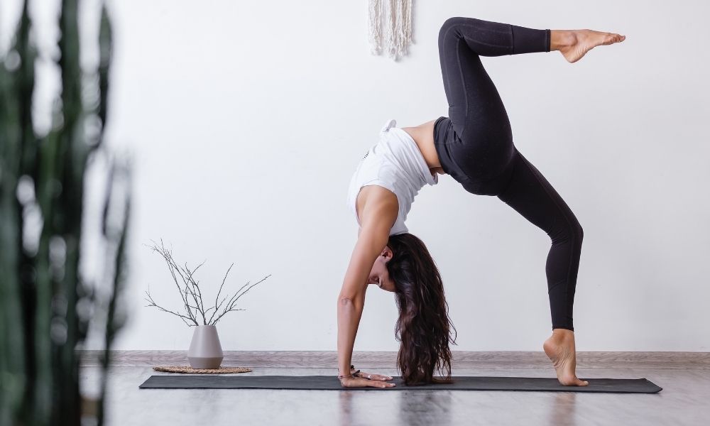 woman doing backbend in yoga studio